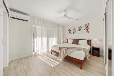 Wake to soft natural light in the primary bedroom, where a king bed, mirrored wardrobes, and calming coastal tones create a peaceful retreat.