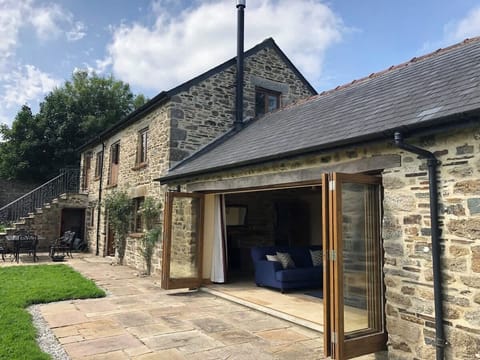 House and garden showing bi-folding door open to the living room