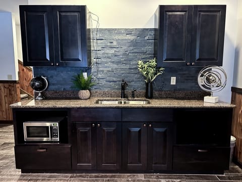 The recreation and game room has a wet bar with second full size fridge, microwave, sink and additional counter space.