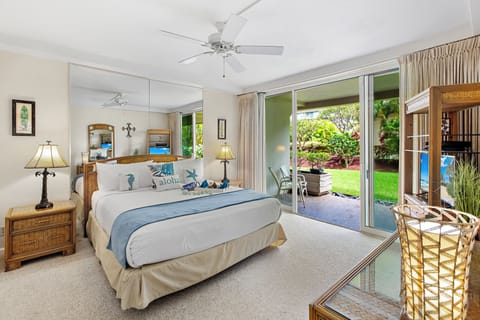 Your serene bedroom opens to tropical gardens, where gentle breezes through sliding doors create the perfect Hawaiian escape.