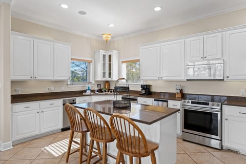 Your spacious kitchen invites culinary adventures with granite counters, white cabinets, and a breakfast bar for morning coffee chats.