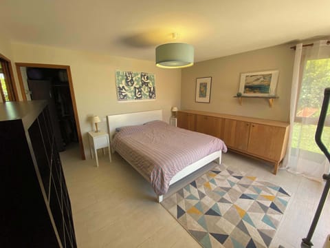 Chambre parentale avec lit double, tapis géométrique et lumière naturelle