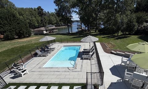 View from the deck overlooking pool, lake, beach, boathouse and fire pit.