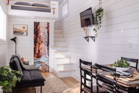 Enjoy meals and conversation in this cozy dining area with seating for four, modern finishes, and an open layout that makes the tiny home feel bright, spacious, and welcoming.