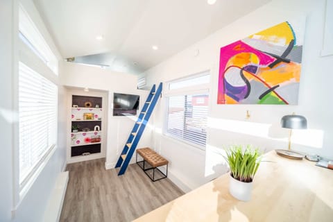 Bright and modern living area featuring loft access, large windows, natural light, and a smart TV. The open layout creates a comfortable space to relax between adventures in Southern Utah.