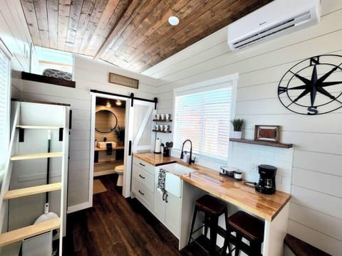 The kitchen is fully equipped with a refrigerator, freezer, microwave, cooktop, and sink with hot/cold water. Enjoy coffee from the coffee maker and ample counter space. Essentials include cookware, dishes, utensils, and plenty of storage cabinets.