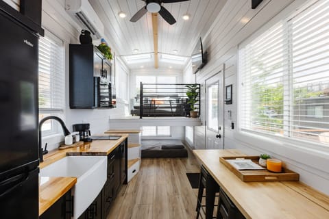 The kitchen is fully equipped with a refrigerator, freezer, microwave, stovetop, and sink with hot/cold water. Enjoy coffee from the coffee maker, with cookware, dishes, utensils, and plenty of storage cabinets to keep everything organized.