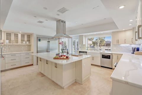 Modern kitchen stocked with cooking essentials + canal view.