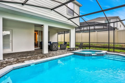 Enclosed lanai with private pool & spa, seating area and lounge chair