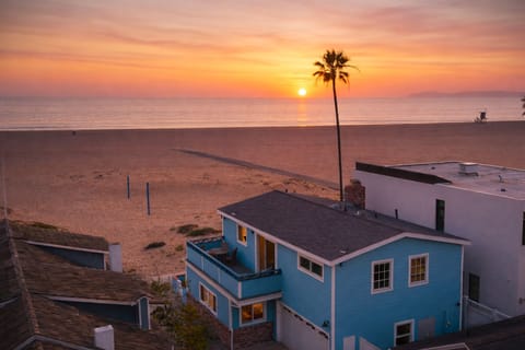 Elevated sunset view of a boardwalk-front beach house just steps from the sand.