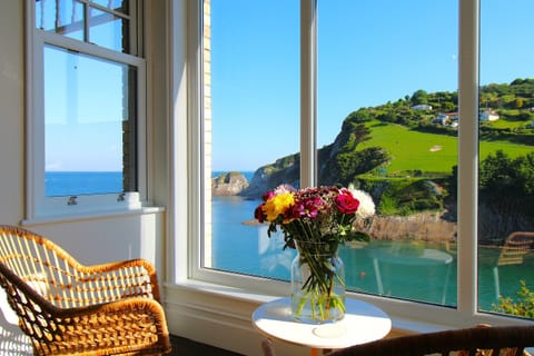Spectacular views of turquoise bay and rolling hills from dining room floor to ceiling window