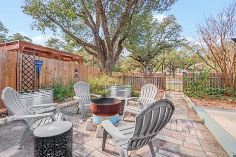 Relax in your private backyard oasis with comfortable Adirondack chairs circled around a cozy fire bowl for evening gatherings.