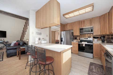 Your open-concept kitchen flows beautifully into the living area, featuring warm wood cabinetry, granite countertops, and stainless steel appliances for memorable meal preparation.