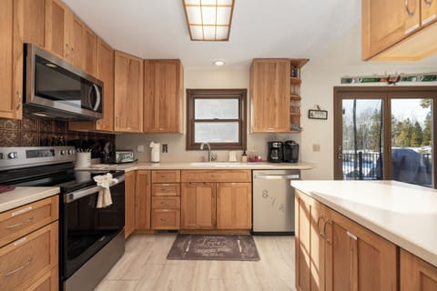 Step into your fully-equipped kitchen where warm wood cabinets and modern appliances await your culinary adventures.