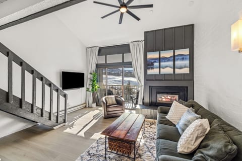 Unwind in your spacious living room with cozy fireplace, mountain views, and modern comforts for the perfect alpine retreat.