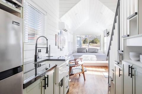 The kitchen is fully equipped with a refrigerator, freezer, microwave, cooktop, and sink with hot/cold water. Enjoy coffee from the coffee maker and ample counter space. Essentials include cookware, dishes, utensils, and plenty of storage cabinets.