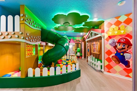Step into a vibrant playroom filled with colorful decor and a fun slide, perfect for entertaining kids. The playful murals and soft flooring create a cheerful atmosphere, making this space an exciting haven for family adventures.