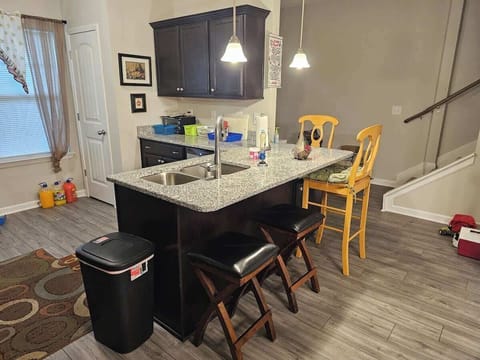 Bright, open kitchen with a large island, bar seating, and modern lighting. The space flows easily into the dining area, making it ideal for casual meals, cooking, and gathering together.