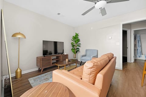 This inviting living area blends mid-century modern design with comfort, featuring a comfy armchair and a statement gold floor lamp.