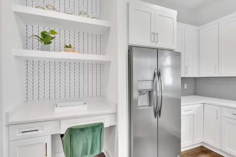 Open-concept kitchen with quartz counters, gas range, and stainless appliances. | Unit B