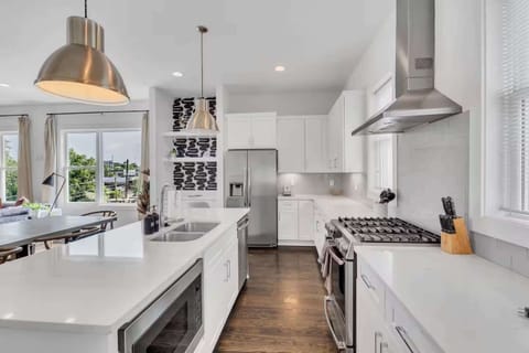 Open-concept kitchen with quartz counters, gas range, and stainless appliances. | Unit A