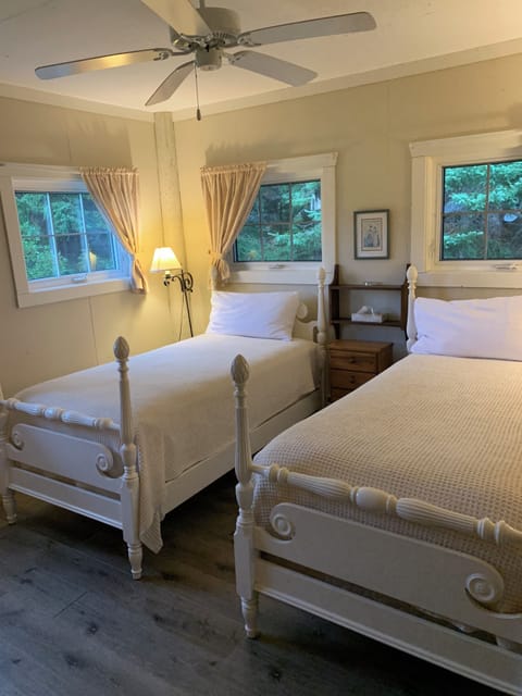 Barn 2 with two single beds. This corner room has four windows, a ceiling fan and a refrigerator