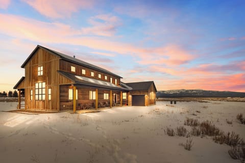 As the sun sets, Mountain Side Manor comes alive—warm lights, snow-kissed fields, and endless mountain views. This is where rustic elegance meets total serenity under Idaho's painted sky.