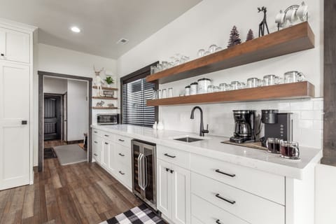 Stretching the length of the kitchen, this fully equipped counter boasts loaded cabinetry, a wine fridge, coffee bar, and prep sink—luxury, function, and style wrapped into one stunning space.
