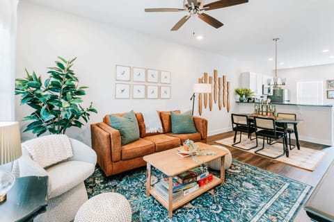 Cozy evenings await with leather sofa, rattan chairs, and natural textures.