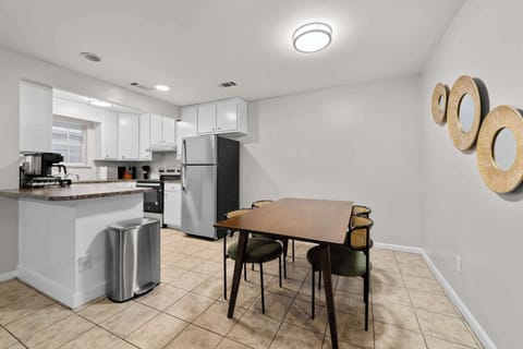 A fully equipped modern kitchen featuring stainless steel appliances and a sleek breakfast bar area.