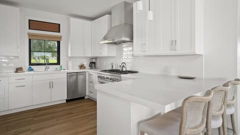Your modern kitchen gleams with white cabinets, stainless steel appliances, and a spacious island for morning coffee and meal prep.