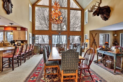 Great room view with dining table, tall windows, kitchen counter, and living area seating.