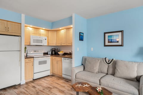 Open kitchen and living flow featuring a breakfast bar, modern lighting, and easy access to the relaxing lounge area.