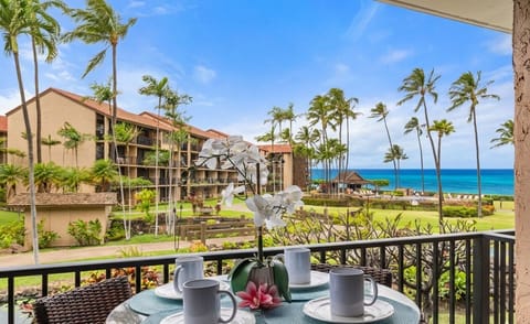 Ocean view lanai with a four‑seat outdoor dining set, perfect for enjoying meals surrounded by tropical palms and resort scenery.