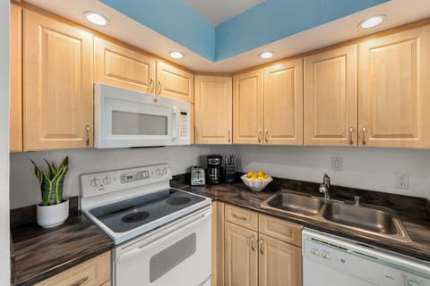 Fully stocked kitchen with stainless-steel appliances, granite countertops, and everything needed for convenient in‑home dining.