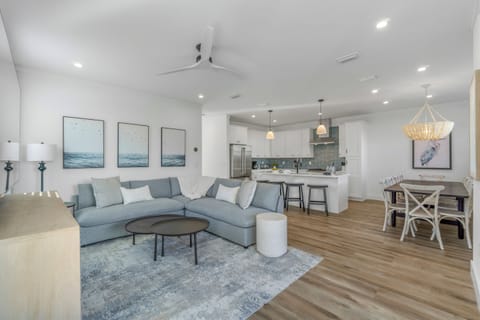 1st Floor - Spacious living room with plush seating and a large Smart TV, designed for large groups to relax together after the beach

