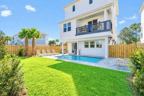 Escape to your private backyard oasis featuring a heated pool, plenty of lounge chairs for soaking up the sun, corn hole, and a covered porch with lounge seating. Dine alfresco at the outdoor dining table or grill out with the gas grill.