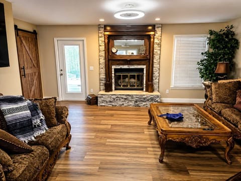 Warm and comfortable living room with cozy seating, hardwood floors, and a fireplace as the focal point. Thoughtfully arranged for relaxation and conversation, creating a welcoming space to unwind.