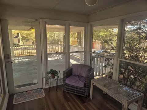 Bright and peaceful sunroom with large windows and glass doors that let in plenty of natural light. A cozy spot to relax, enjoy your morning coffee, or unwind while taking in the surrounding views.