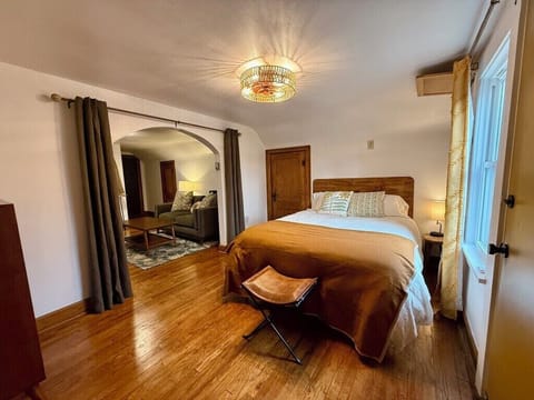 Bedroom with plush Queen size bed, multi-plug charging bedside lamp.