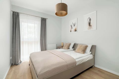 Comfortable bedroom with a double bed, soft bedding and large window providing natural daylight and a calm atmosphere.