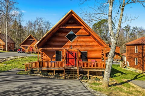 Charming log cabin features warm wood exterior with inviting front porch in peaceful wooded setting.