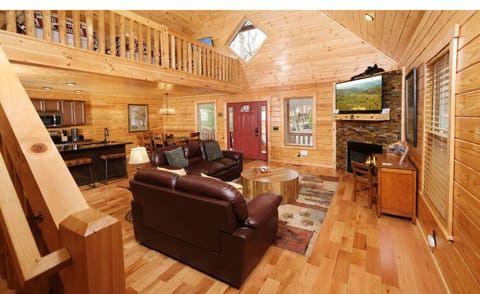 Cozy up in this warm cabin living room with rich leather seating and crackling fireplace for perfect mountain evenings.