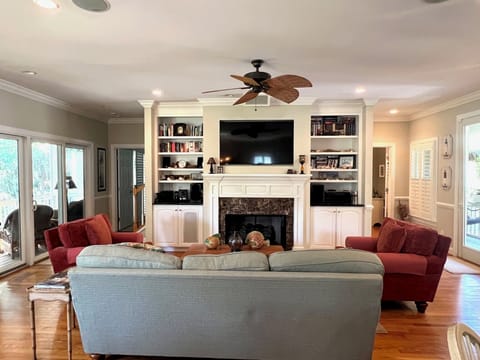 Comfortable living area with a large TV and cooling fan.
