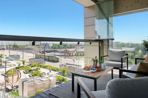 Sweeping city views are embraced from the spacious glazed balcony, where treats are enjoyed as vibrant urban scene comes to life.