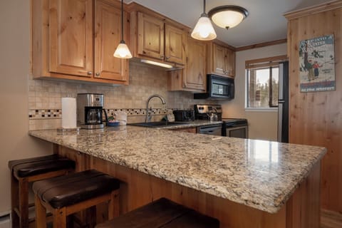 Your fully equipped kitchen features granite counters, warm wood cabinets, and everything needed for home-cooked meals.