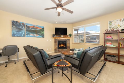 Settle into your cozy living room where leather seating surrounds a warm fireplace, perfect for relaxing evenings after your mountain adventures.
