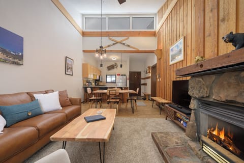 Cozy up by your crackling fireplace in this warm, wood-accented living space with soaring ceilings and mountain lodge charm.