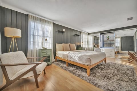 Bedroom with queen bed, chair, and side table