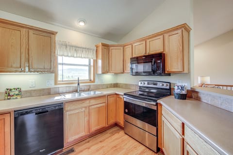 Your fully equipped kitchen features warm wood cabinets, stainless appliances, and ample counter space for preparing home-cooked meals during your stay.
